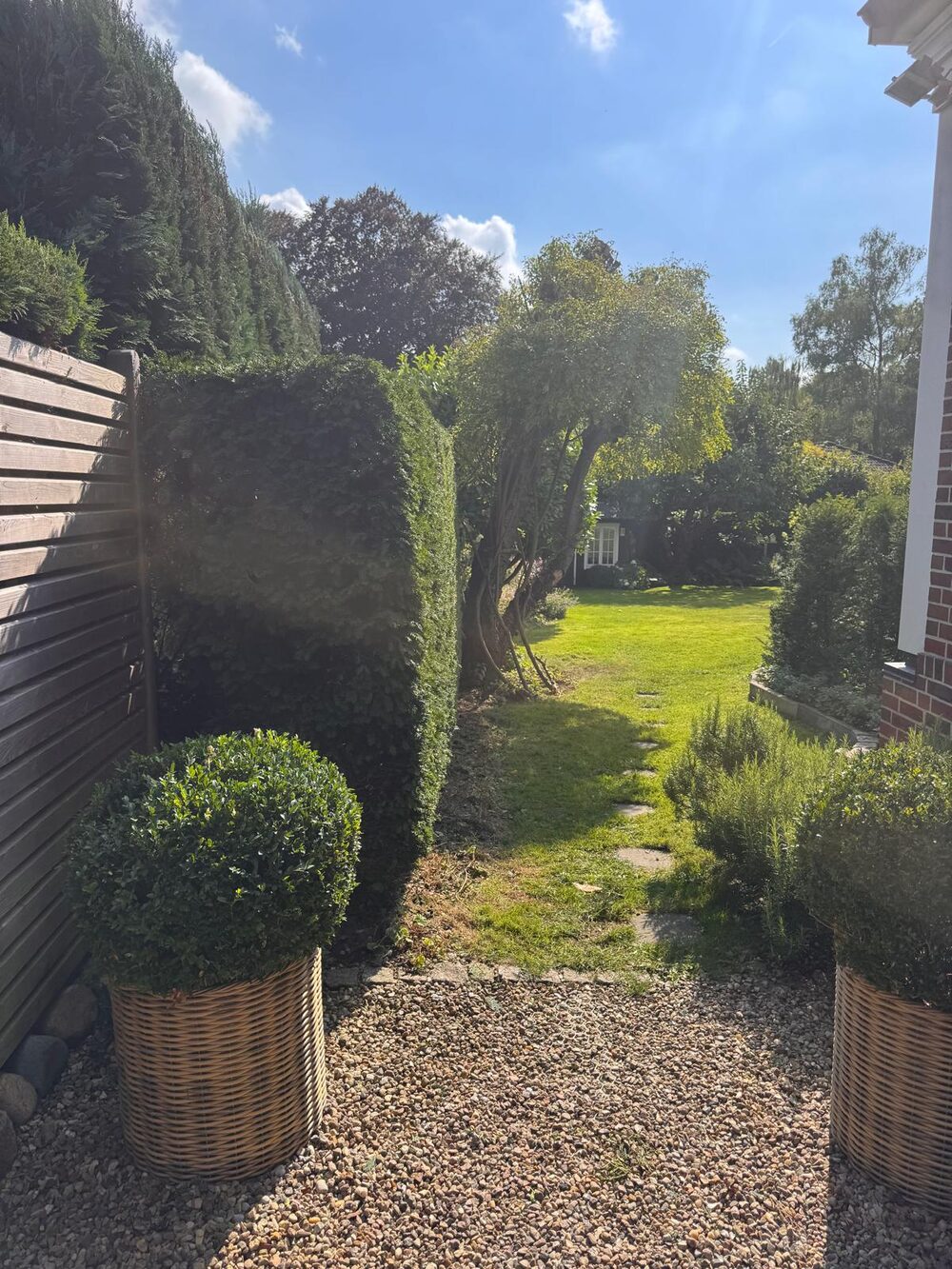 Garten mit Rasen, Hecken und Beeten.